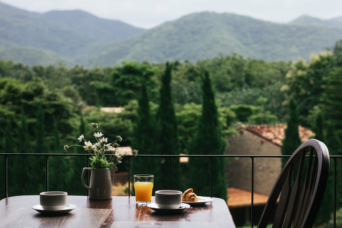 Lee más sobre el artículo Breakfast on a wooden table with a natural view
